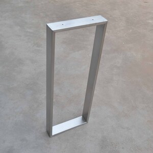 May include: A silver metal table leg with a rectangular frame.