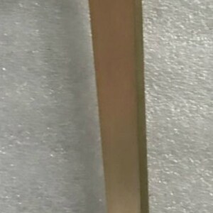 May include: A gold metal table leg with a triangular top. The leg is about 18 inches long.