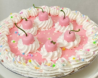 Pink fake pie, fake food, fake whipped cream pie, pink cherries