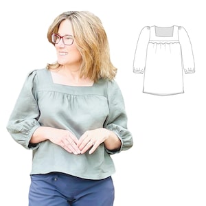 Puede incluir: Una mujer con una blusa de lino verde salvia con cuello cuadrado y mangas tres cuartos. La blusa tiene un detalle fruncido en el escote y se combina con pantalones azul marino. Un dibujo lineal de la blusa está al lado de la mujer.