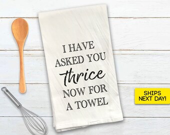 May include: White kitchen towel with black text that reads "I have asked you thrice now for a towel".