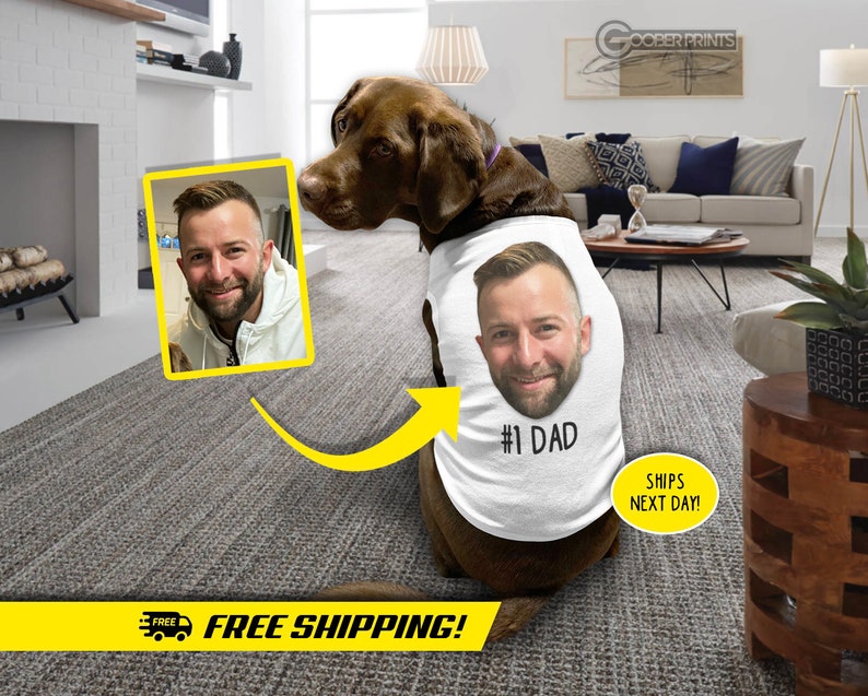 May include: A brown dog wearing a white tank top with a photo of a person's face and the text "#1 DAD".