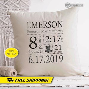 May include: A white pillow with black text and a small teddy bear graphic. The text reads "EMERSON", "Emerson May Matthews", "8 pounds", "6 ounces", "2:17 PM", "21 inches", and "6.17.2019".
