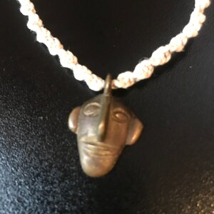 Handmade macramé necklace with a tribal face pendant