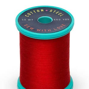 May include: A spool of vibrant red sewing thread with teal plastic ends. The top label is dark gray with yellow text reading COTTON + STEEL, 50 WT, 660 YDS, and orange text reading SEW WITH LOVE. The thread is wound tightly around the central cylinder.