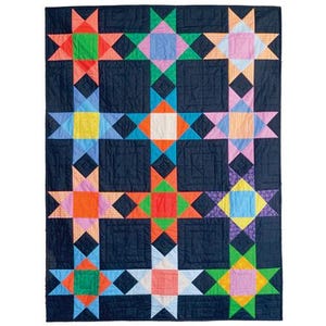 May include: A rectangular quilt featuring a dark navy blue background with a repeating pattern of multi-colored stars. Each star is composed of various fabric squares in shades of orange, green, pink, yellow, light blue, and white, with visible stitching throughout the fabric surface.