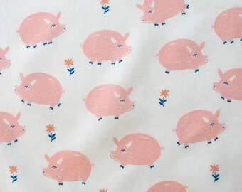 May include: A white fabric featuring a repeating pattern of light pink pigs with blue eyes and small orange flowers with blue stems. The pigs are depicted in a side profile view, and the design is evenly distributed across the entire surface.
