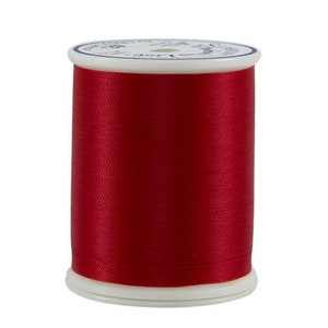 May include: A spool of red thread.
