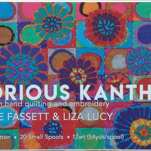 May include: A rectangular box set of 20 small spools of 12wt Aurifil cotton thread for big stitch hand quilting and embroidery. The packaging features a vibrant, multi-colored floral pattern and the text Glorious Kantha by Kaffe Fassett & Liza Lucy.