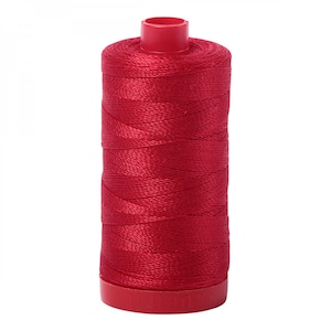 May include: A spool of red thread with a red plastic bobbin.
