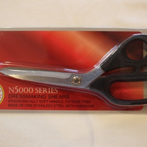 May include: Black handled dressmaking shears with a silver blade. The shears are 8 inches long and made of fine stainless steel with vanadium. The packaging features the text "N5000 Series Dressmaking Shears" and "Kai Original".