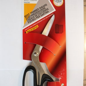 May include: A red and white package with a pair of 9-inch Kai N5230 bent trimmer shears. The shears are made of high carbon stainless steel with vanadium and have black handles. The package says "Soft Handle Feeling Good" and "Kai original".
