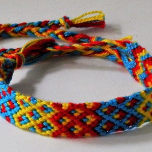 以下が含まれることがあります： 赤、黄色、青の織り模様が施されたカラフルな友情ブレスレットです。