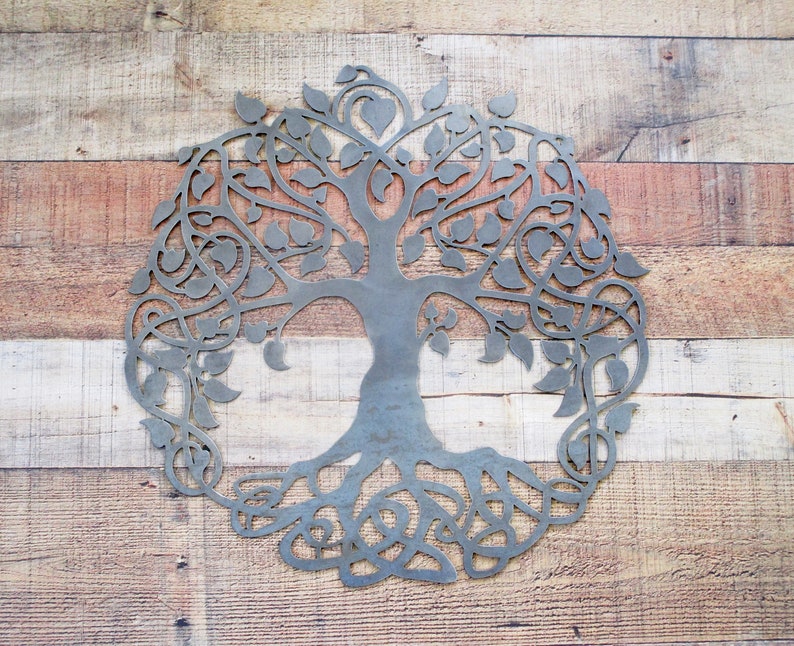 May include: A metal tree of life wall decor with intricate branches and roots. The tree is cut out of metal and has a rustic, weathered finish.