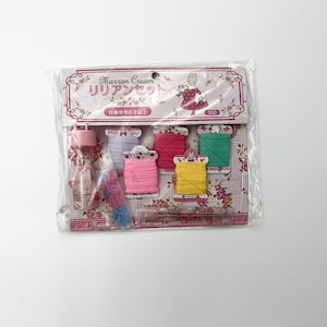 May include: A craft kit in a clear plastic package. The kit includes spools of thread in various colors, a small bottle, and other craft supplies. The packaging features the text "Marron Cream" and Japanese text, along with a floral design.