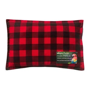 May include: A rectangular, red and black buffalo plaid heating pad. The pad has a label with the text "Productive Parrot" and a colorful parrot illustration. The pad is designed for therapeutic use.