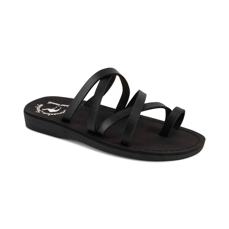 K&ouml;nnte beinhalten: Schwarze Ledersandalen mit mehreren Riemen und einem Zehenring. Die Sandalen haben eine flache Sohle und sind von der Marke "Journey Soul".
