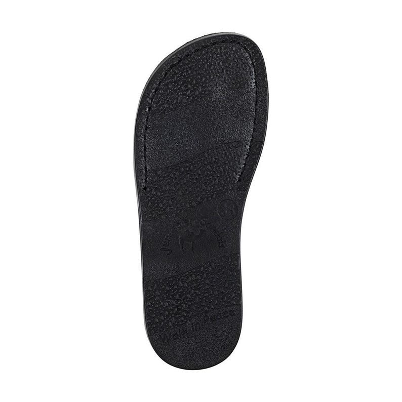 K&ouml;nnte beinhalten: Schwarze Flip-Flop-Sohle mit einer strukturierten Oberfl&auml;che und dem Aufdruck "Made in Brazil" auf der Unterseite.