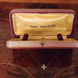 May include: A purple velvet jewellery box with a gold interior and the words "PAUL VALLETTE" printed on the inside.