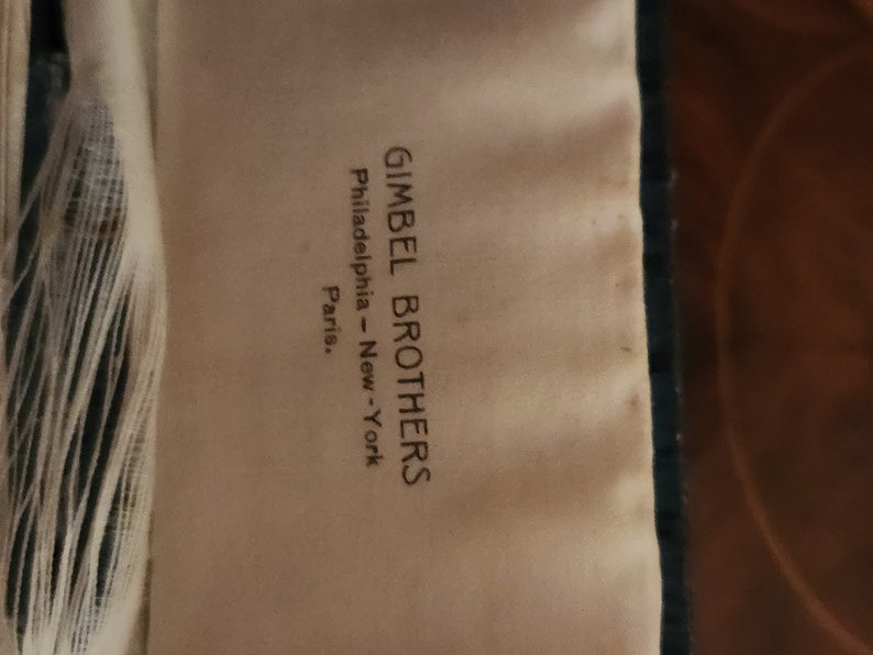 May include: A white tag with black text that reads "Gimbel Brothers Philadelphia - New York Paris."