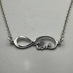 May include: Silver necklace with an infinity symbol pendant that says "Love" inside the loop.