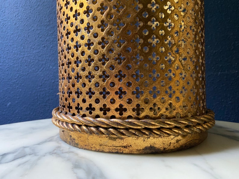 May include: Gold metal lampshade with a decorative, intricate pattern and a rope-like trim around the bottom edge.