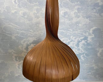 May include: A brown wooden pendant light with a unique, twisted design. The light is suspended from a rope chain.