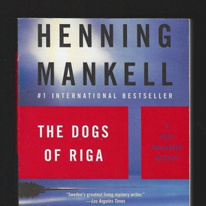May include: Book cover for "The Dogs of Riga" by Henning Mankell. The title is in large white letters on a red background. The cover features a wooden pier extending into a body of water under a blue sky.