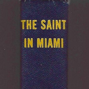 May include: A close-up of a book cover with the title "THE SAINT IN MIAMI" in gold lettering on a dark blue textured background. The author's name, LESLIE CHARTERIS, is also in gold.