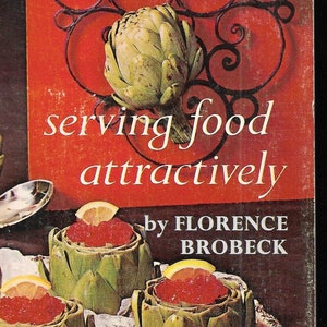 May include: A vintage cookbook cover with the title "serving food attractively" by Florence Brobeck. The cover features a red background with a black metal design and a still life of artichokes and caviar.