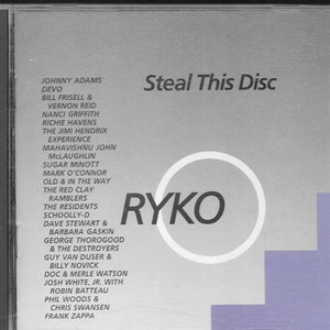 May include: A silver CD case with a white circle and the word "RYKO" printed in black. The case has a list of artists and bands printed on the front, including Johnny Adams, Devo, Bill Frisell, Vernon Reid, Nanci Griffith, Richie Havens, The Jimi Hendrix Experience, Mahavisnu John McLaughlin, Sugar Minott, Mark O'Connor, Old & In The Way, The Red Clay Ramblers, The Residents, Schoolly-D, Dave Stewart & Barbara Gaskin, George Thorogood & The Destroyers, Guy Van Duser & Billy Novick, Doc & Merle Watson, Josh White, Jr. with Robin Batteau, Phil Woods & Chris Swansen, and Frank Zappa. The case also has the words "Steal This Disc" printed in black.