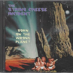 May include: CD cover art for the album "Born on the Wrong Planet" by The String Cheese Incident. The cover features a surreal landscape with a large rock formation and a group of babies in diapers.