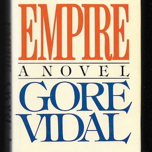 May include: A white book cover with the title "EMPIRE" in orange letters and the author "GORE VIDAL" in blue letters. The text "A NOVEL" appears in black letters below the title.