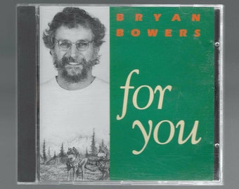 May include: A CD case with a green background and the text "BRYAN BOWERS for you" in white. A black and white photo of a man with a beard is on the left side of the case. A black and white drawing of two wolves is on the bottom left side of the case.