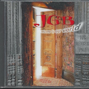 May include: A red, white, and blue sign with the text "JGB welcome to our world!"  The sign is in front of a doorway with a carved wooden door. The text "FOR MEMBERS ONLY" is on a silver sign to the right of the doorway.