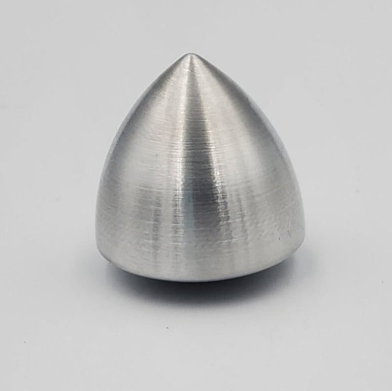 Puede incluir: Una peonza de metal plateado con una punta puntiaguda y un acabado liso y cepillado.