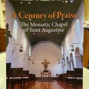 Op de afbeelding: Een boekomslag met de titel "A Century of Praise: The Monastic Chapel of Saint Augustine". De omslag toont een foto van het interieur van een kapel met houten banken, een houten vloer en een kruis op het altaar.