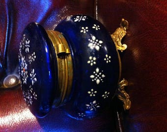 May include: A blue and white porcelain trinket box with gold accents and a hinged lid. The box is decorated with a floral pattern.