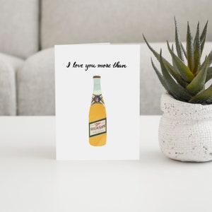 May include: A white card with black text that reads "I love you more than" and a cartoon illustration of a yellow beer bottle with the text "High Life" on the label.