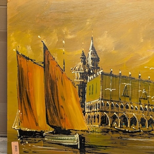 May include: An oil painting depicting a Venetian scene with sailboats and buildings. The sailboats have orange sails, and the buildings are in shades of green and white. The sky is a golden yellow.