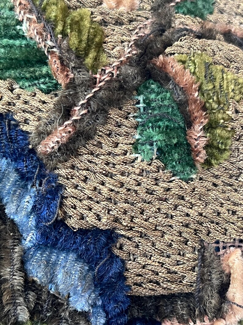 May include: Close-up of a textured fabric with a patchwork design. The fabric is made of different colors and textures, including brown, green, blue, and pink. The fabric is stitched together in a random pattern.