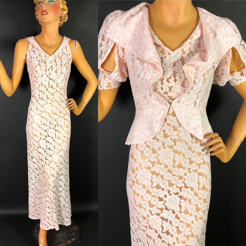 May include: A pink lace dress with a ruffled neckline and short sleeves. The dress is sheer and has a floral pattern.