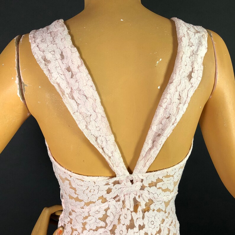 May include: A pink lace top with a V-shaped back and a criss-cross design in the back.