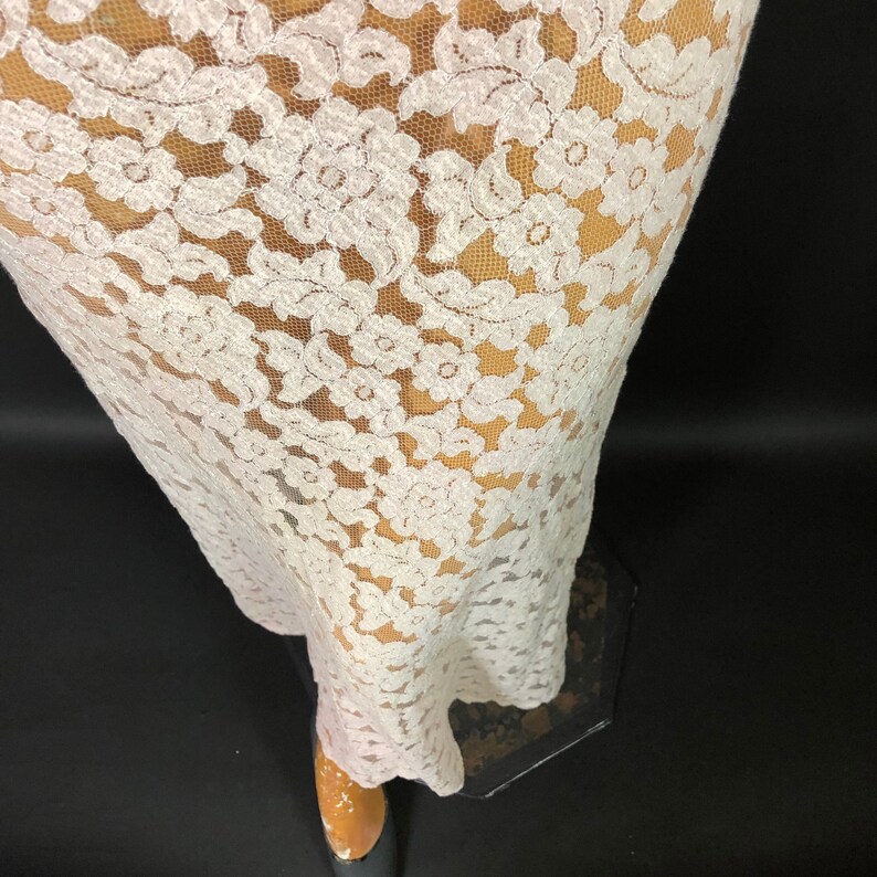 May include: White lace fabric with a floral pattern. The lace is sheer and delicate, with a soft, flowing texture.