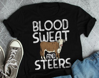 May include: Black t-shirt with a white graphic that says "Blood Sweat and Steers" with a brown and white steer illustration.