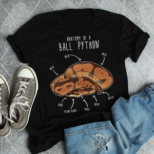 Peut inclure: T-shirt noir avec un graphique blanc d'un python royal avec le texte "Anatomie d'un python royal" et des étiquettes pour différentes parties du corps du serpent.