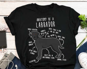 May include: A black t-shirt with a humorous illustration of a Labrador Retriever. The illustration is labeled with anatomical features such as "Snack Inhaler", "Extra Snack Storage", and "Belly Full of Questionable Items".