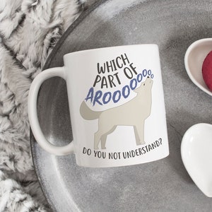 May include: White ceramic coffee mug with a wolf howling and the text "Which part of AROOOOOO do you not understand?" printed on it. The mug is on a gray tray with two white heart-shaped dishes.
