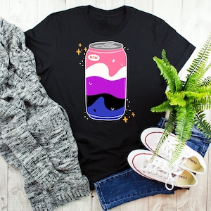 Puede incluir: Camiseta negra con un gráfico de una lata de refresco con un diseño rosa, morado, azul y negro. La lata tiene la palabra "NEW" en ella.