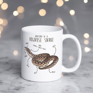 May include: White ceramic mug with a brown and white illustration of a hognose snake with the text "Anatomy of a Hognose Snake" and labels for the snake's body parts.